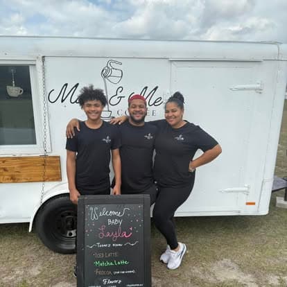 The Marie & Me Coffee team in front of the trailer with the welcome chalkboard